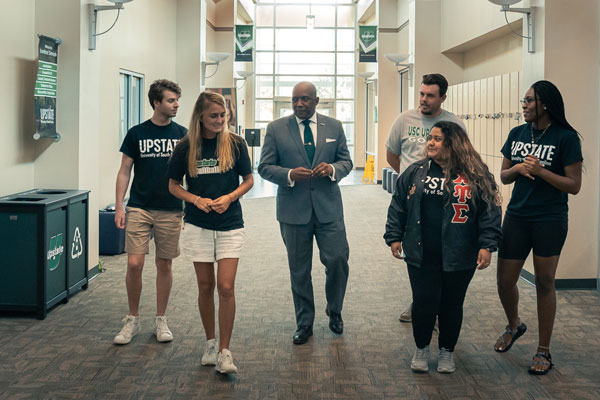 Dr. Bennie Harris walking with students