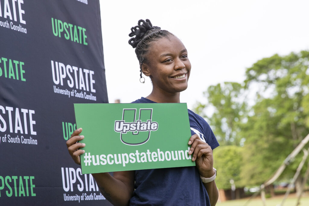 A admitted student holds a USC Upstate sign