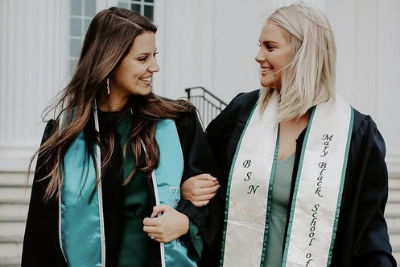 two women of the kappa rho chapter of zeta tau alpha smile at each other