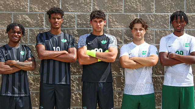 a group of men standing in front of a wall