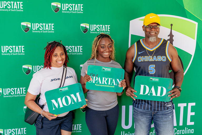A happy future student and family showing their USC Upstate Pride holding a I'm a Spartan Sign.