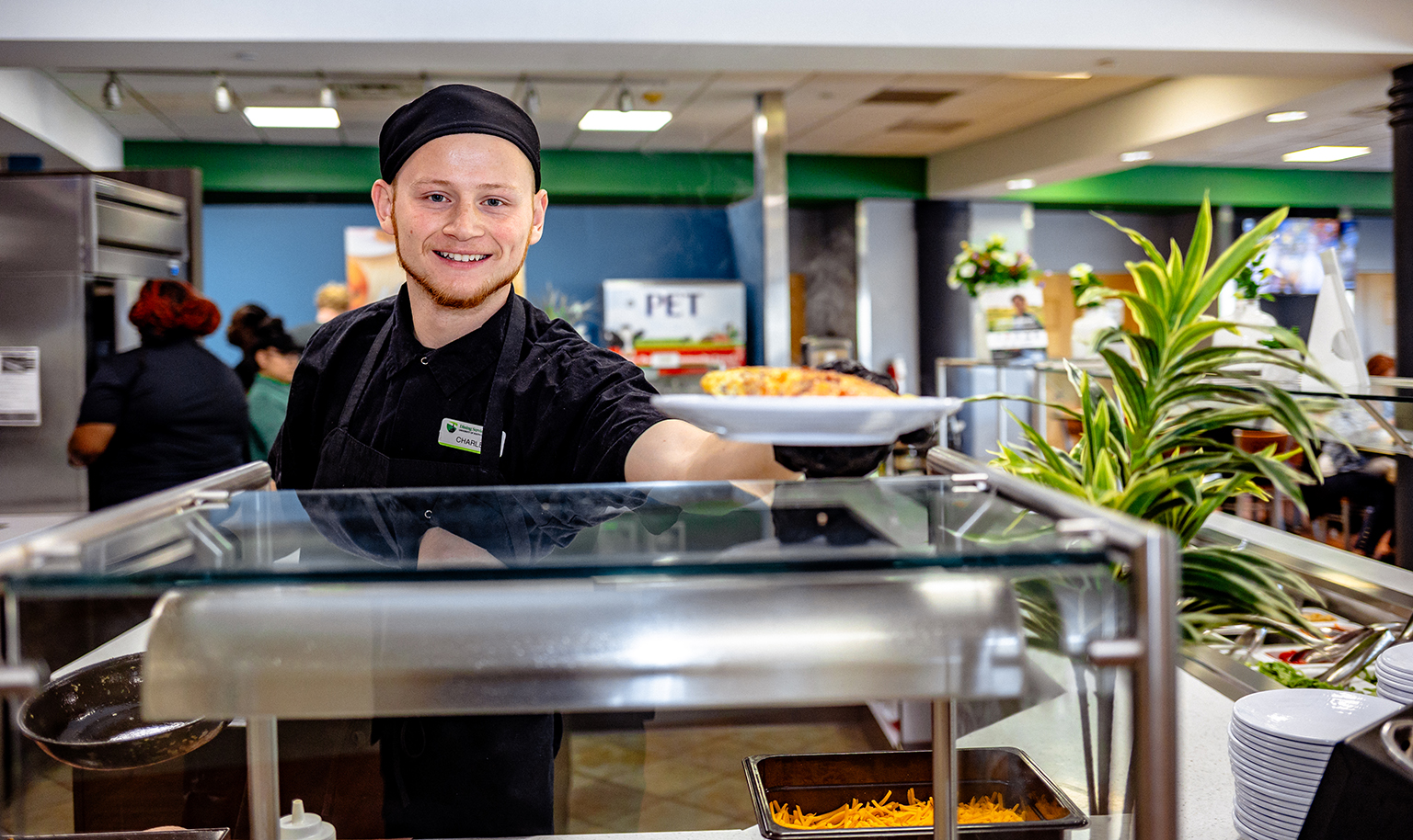 Dining at USC Upstate - smiling food services team member serving breakfast