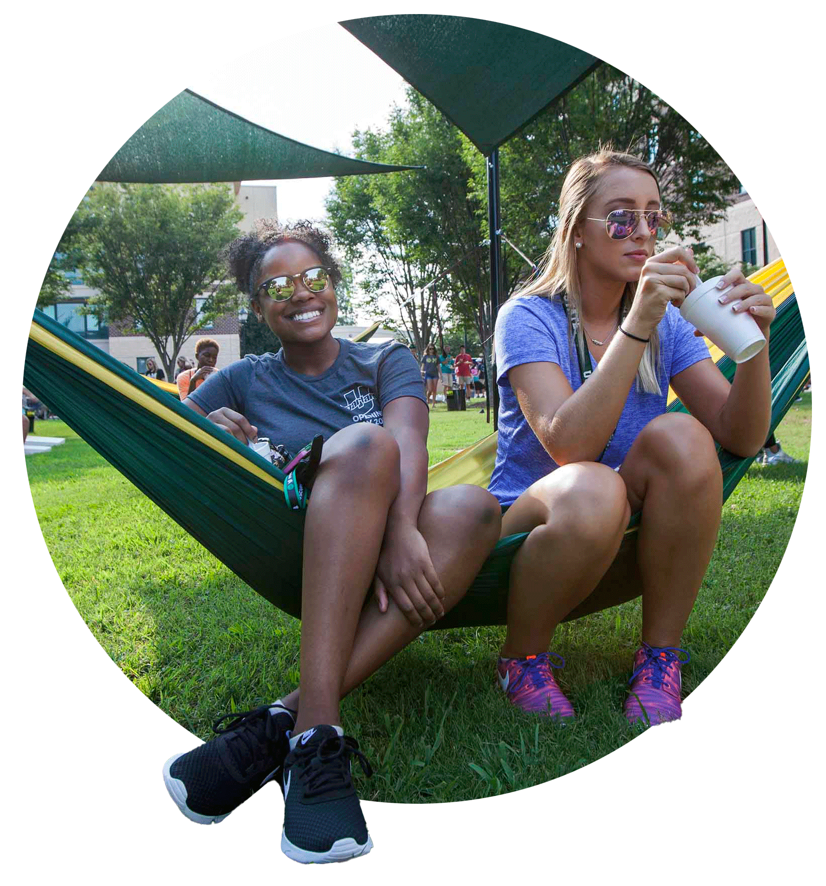 Two smiling students sitting outside