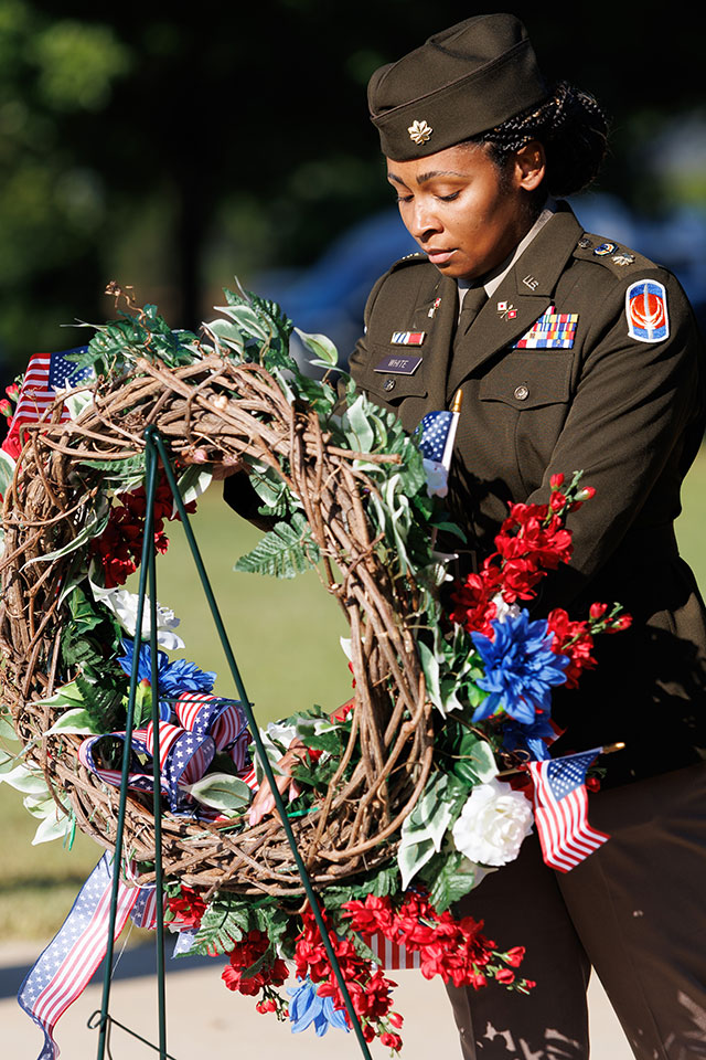 a person in a military uniform holding a wreath