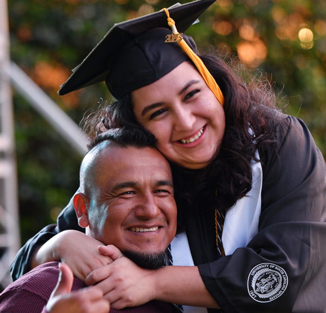 Graduation photo of couple hugging and celebrating.