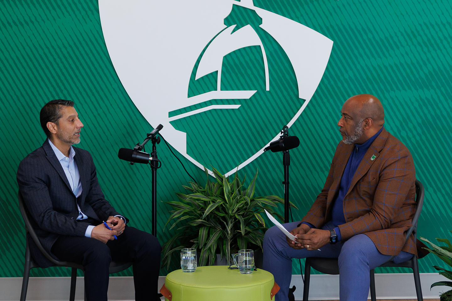 Avi Lawrence and Dr. Bennie Harris sit at microphones on the Below The Line podcast