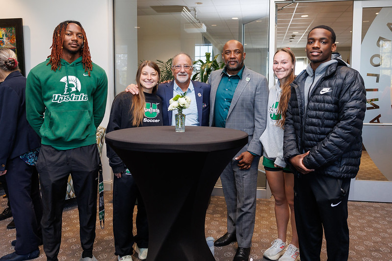 Photo of multiple people gathered around a table