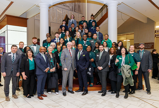 USC Upstate students and faculty pose on steps with USC President Michael Amiridis and Upstate Chancellor Bennie Harris