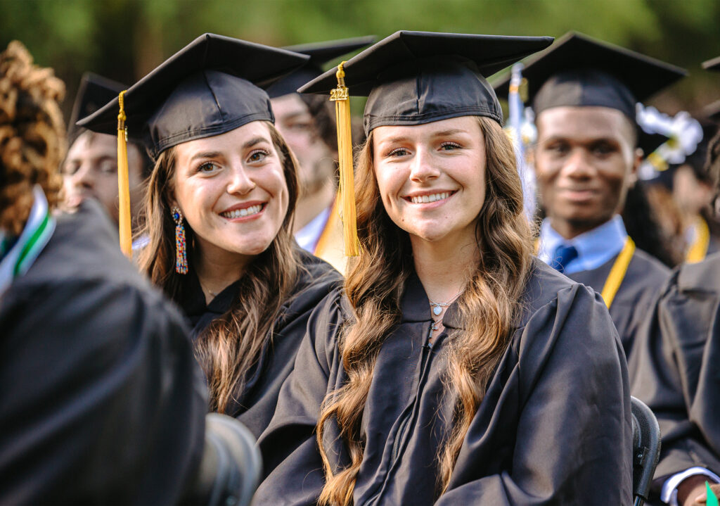 students smile in graduation caps