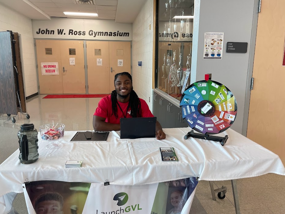 College student sits at an informational booth