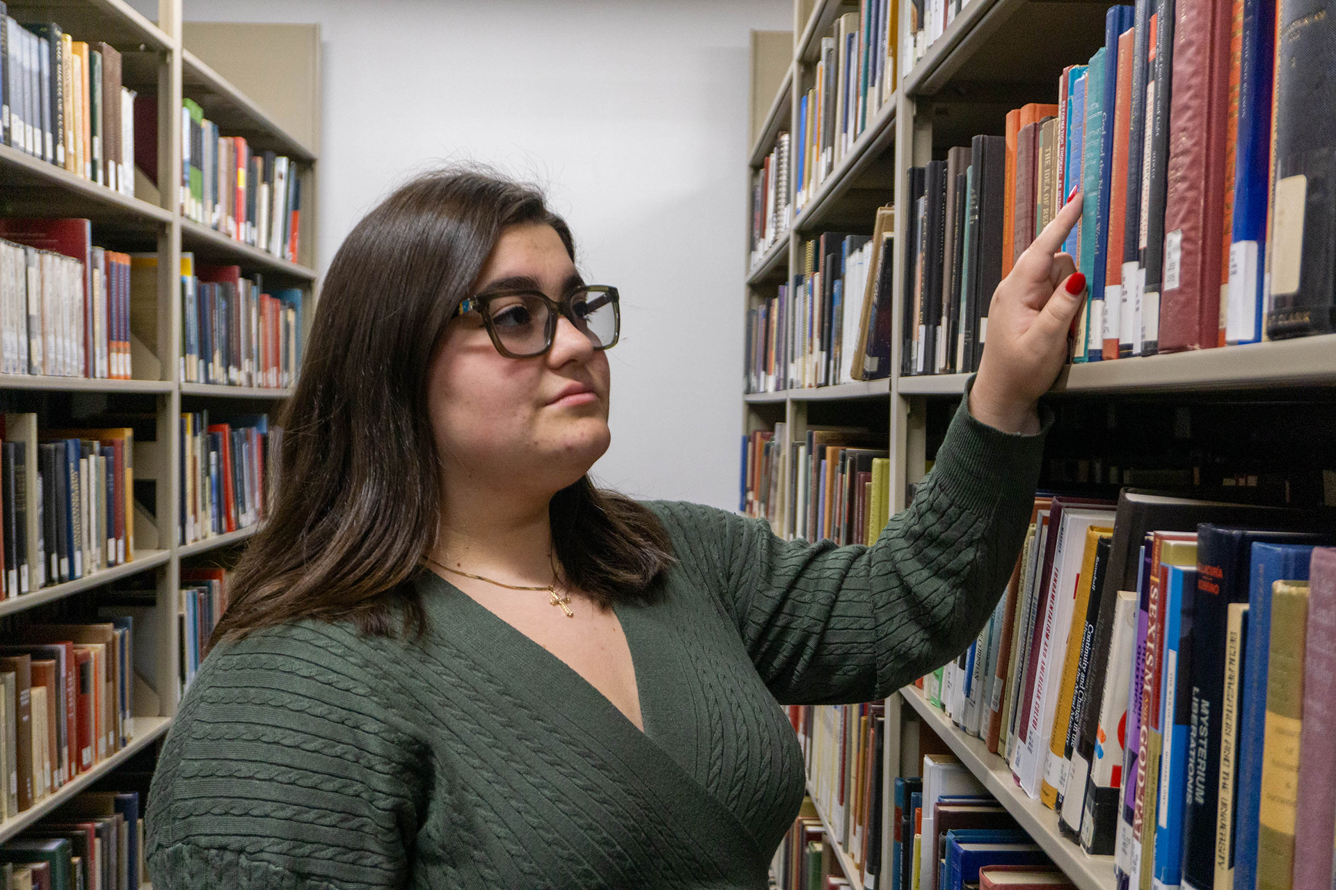 student looks at a row of books  