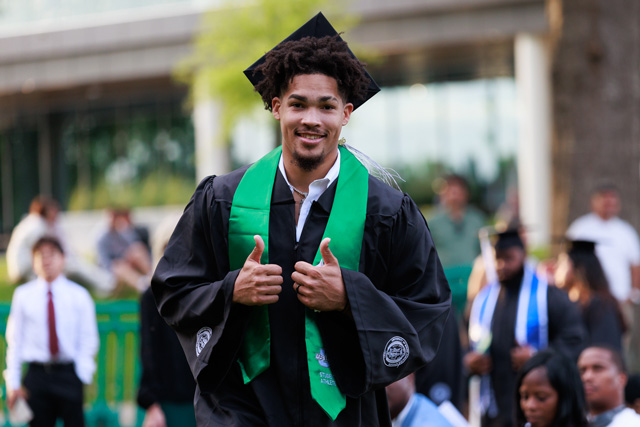 Graduating student giving a thumbs up
