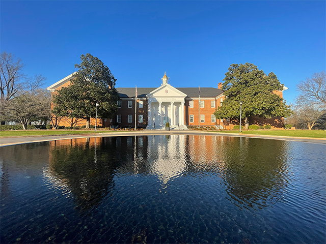 USC Upstate's Administration Building reflected in the circular fountain  