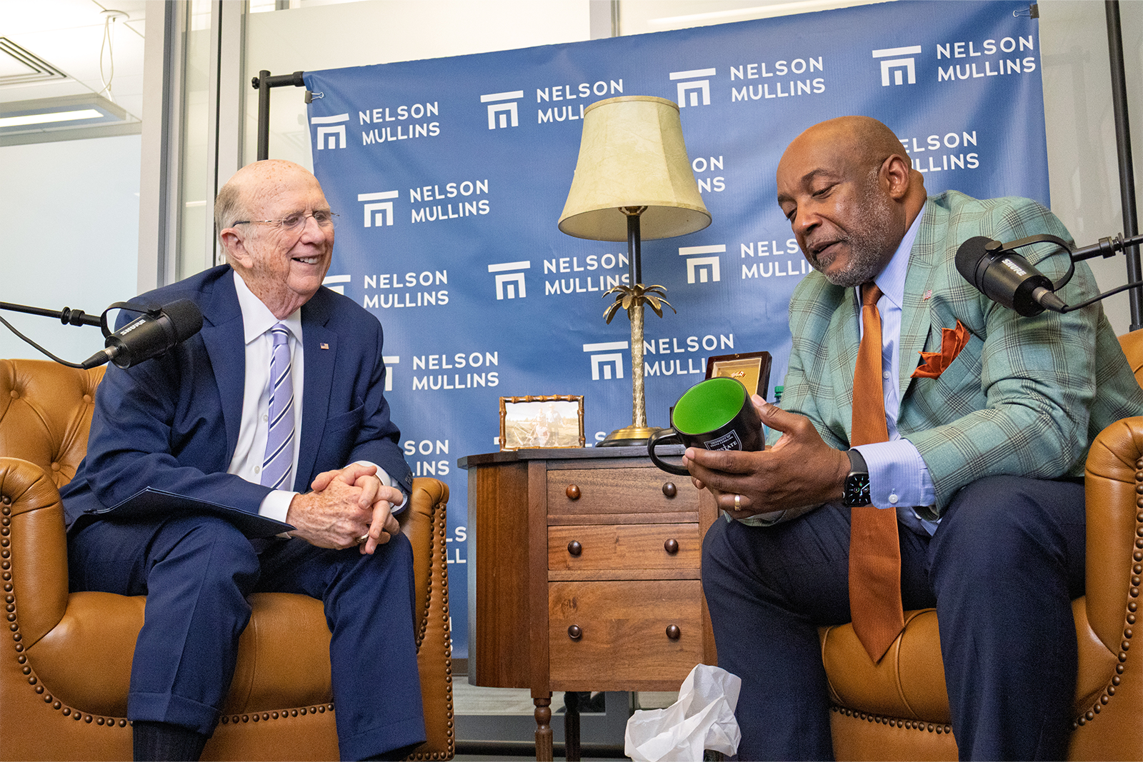 David Wilkins speaks with Chancellor Bennie L. Harris while looking at a coffee mug.