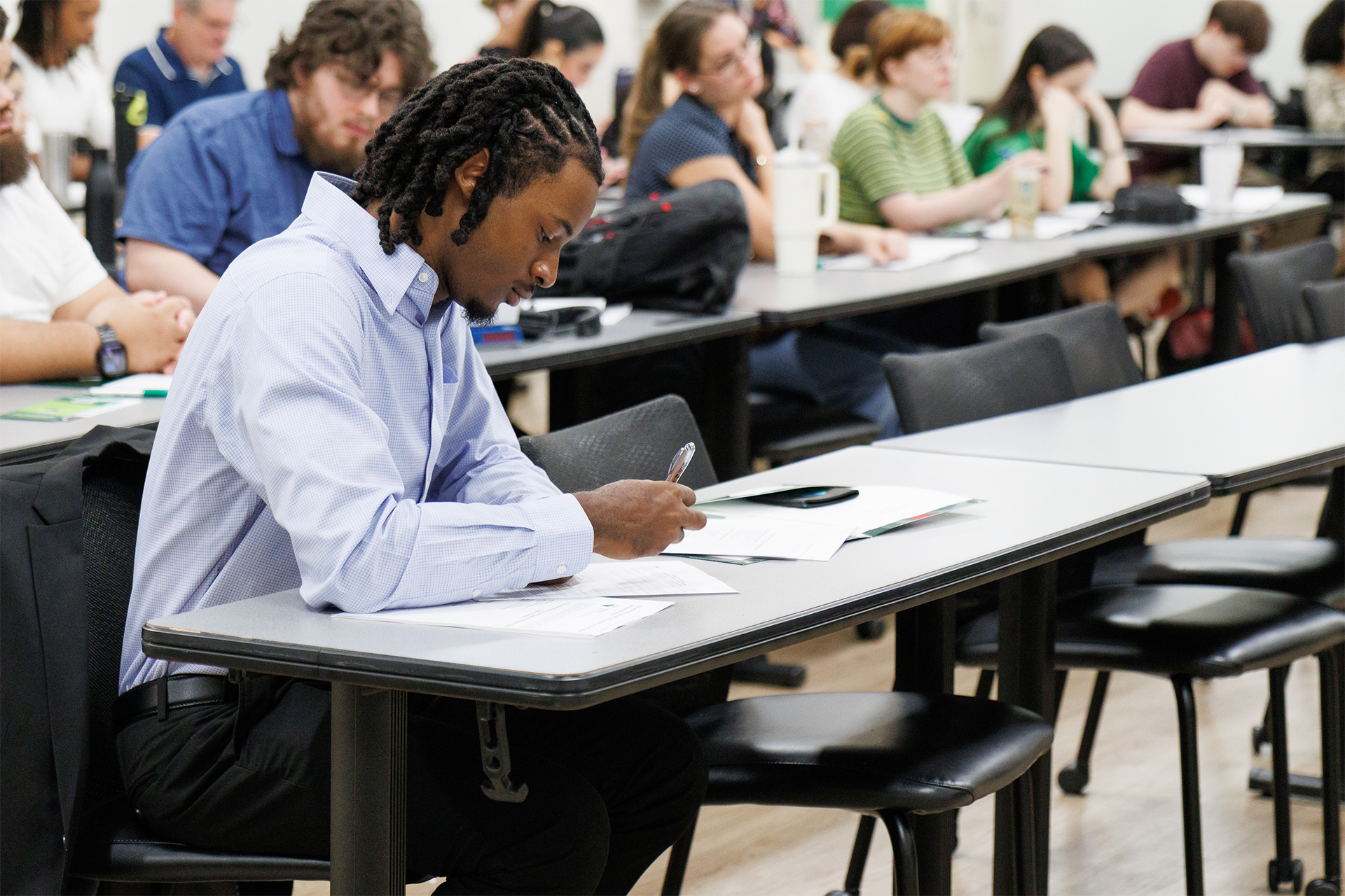 a student writes at a desk